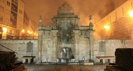 As Burgas thermal fountain lit up at night in Ourense._345