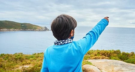 Niño observa el mar.